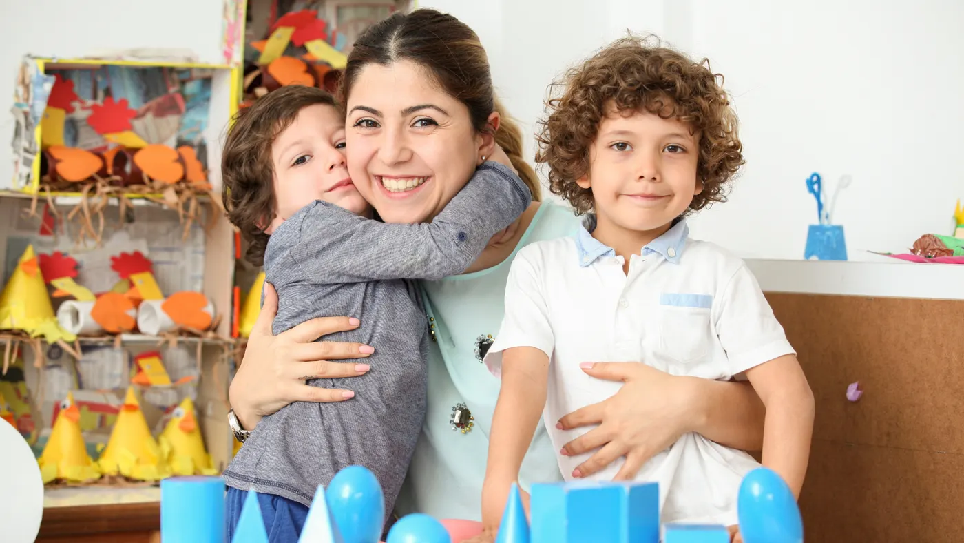 אשת צוות מחבקת ילדים